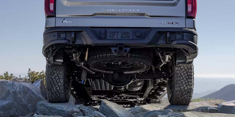 A GMC Sierra 1500 driving over rocks, highlighting its off-road capability